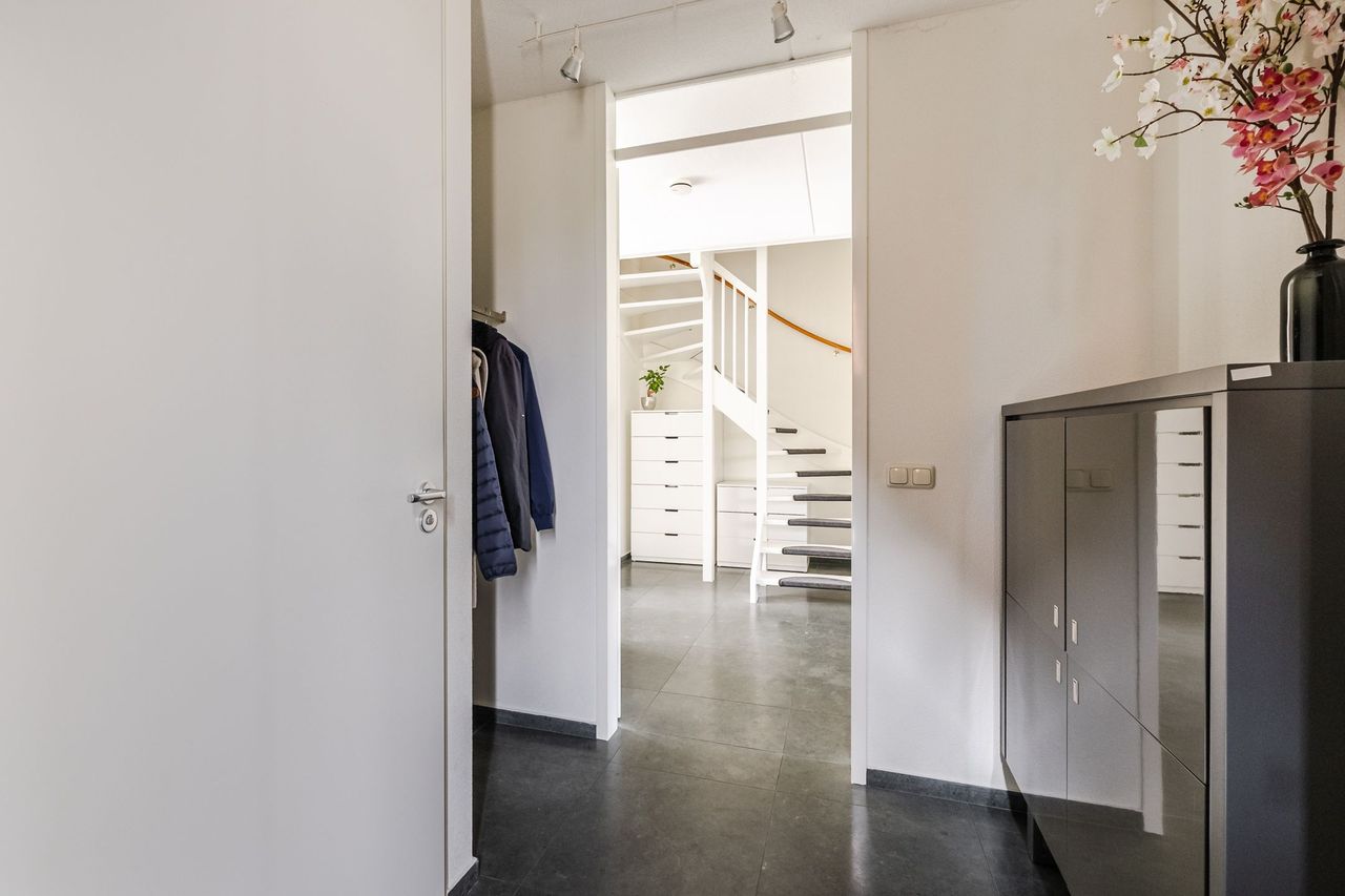 De entree met garderobe en de deur naar de woonkamer