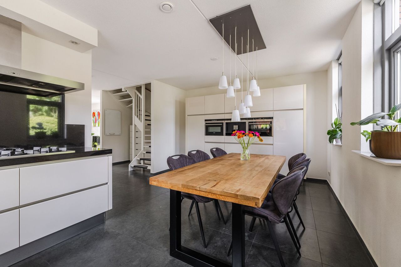 De keuken met de eettafel en de trap naar de eerste verdieping