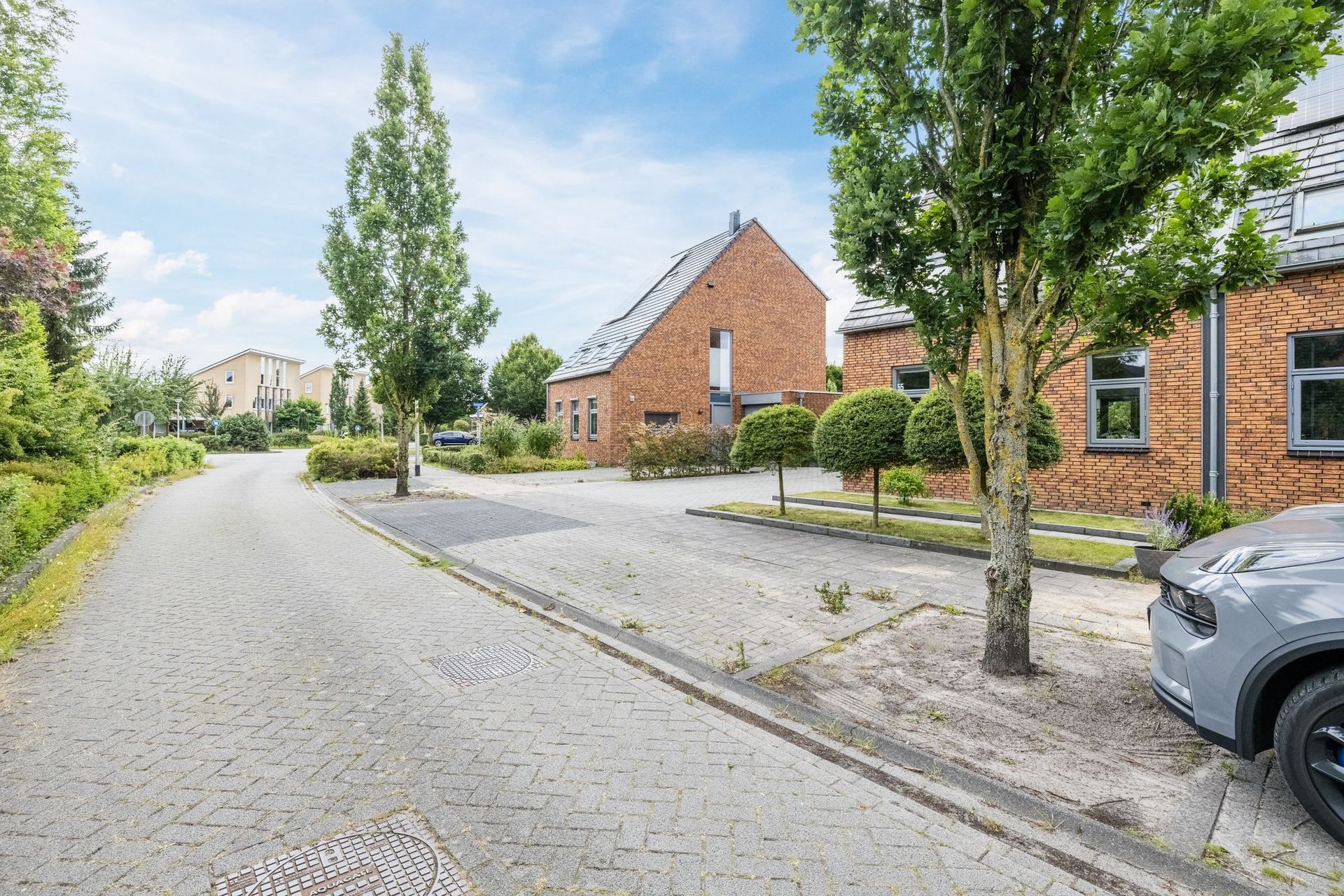 De rustige straat in Kloosterveen waaraan Bosrank 55 ligt, met volgroeide bomen