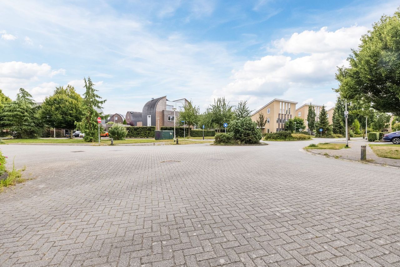 De brede, rustige straat in Kloosterveen met groenperken en ruimte tussen de woningen