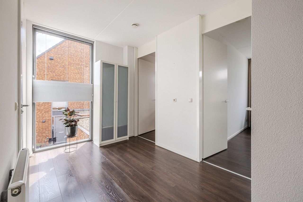 De overloop met een hoog raam dat veel daglicht binnenlaat