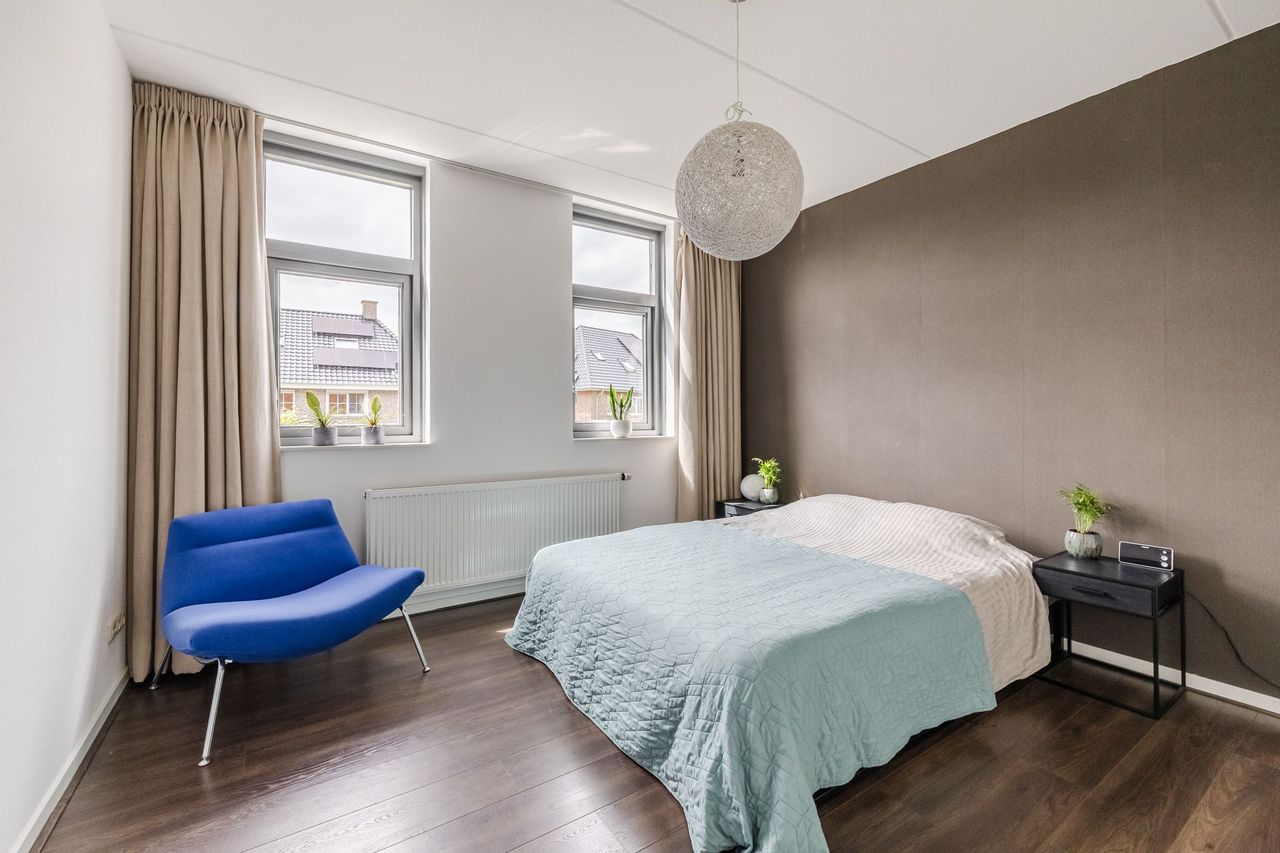 De ruime ouderslaapkamer met tweepersoonsbed en twee ramen aan de voorzijde