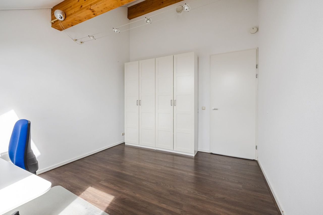 Lege zolderkamer met inbouwkast en balk in het plafond