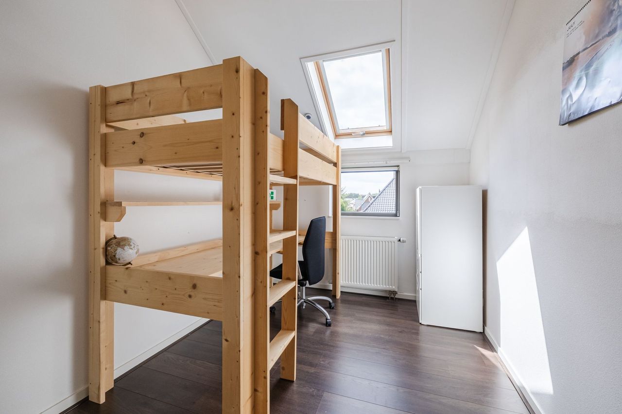 Kinderkamer met hoogslaper en bureau eronder